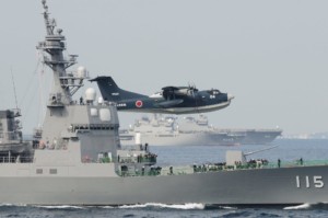 Un idrovolante Shinmaywa US-2I sorvola un caccia classe Kongo. Alcuni esemplari dell'aereo potrebbero essere acquistati dall'India in seno agli ultimi accordi bilaterali.